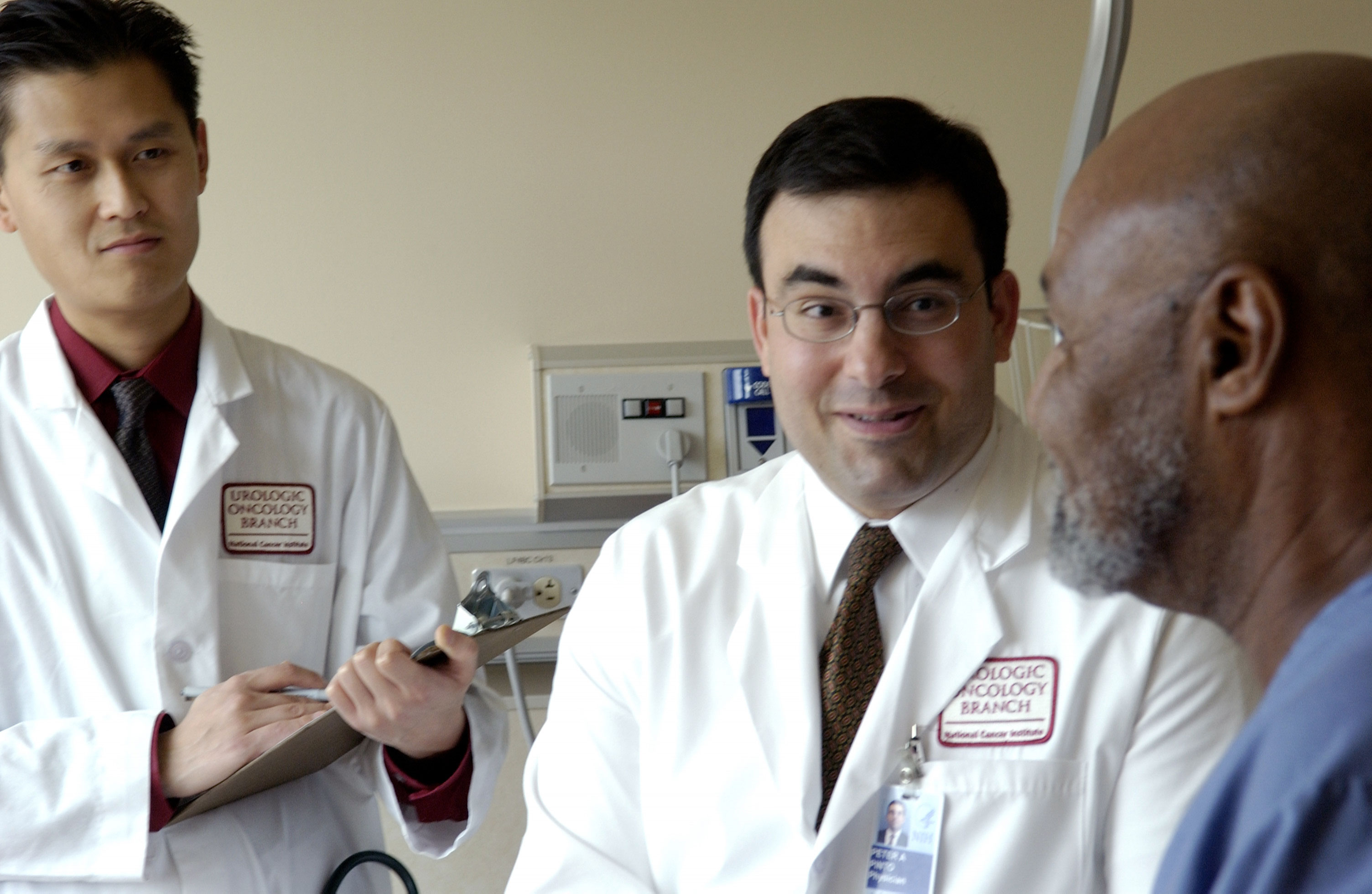 A photo of two doctors and a patient.