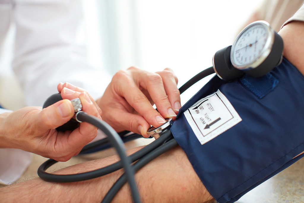 A photo of a doctor checking blood pressure.